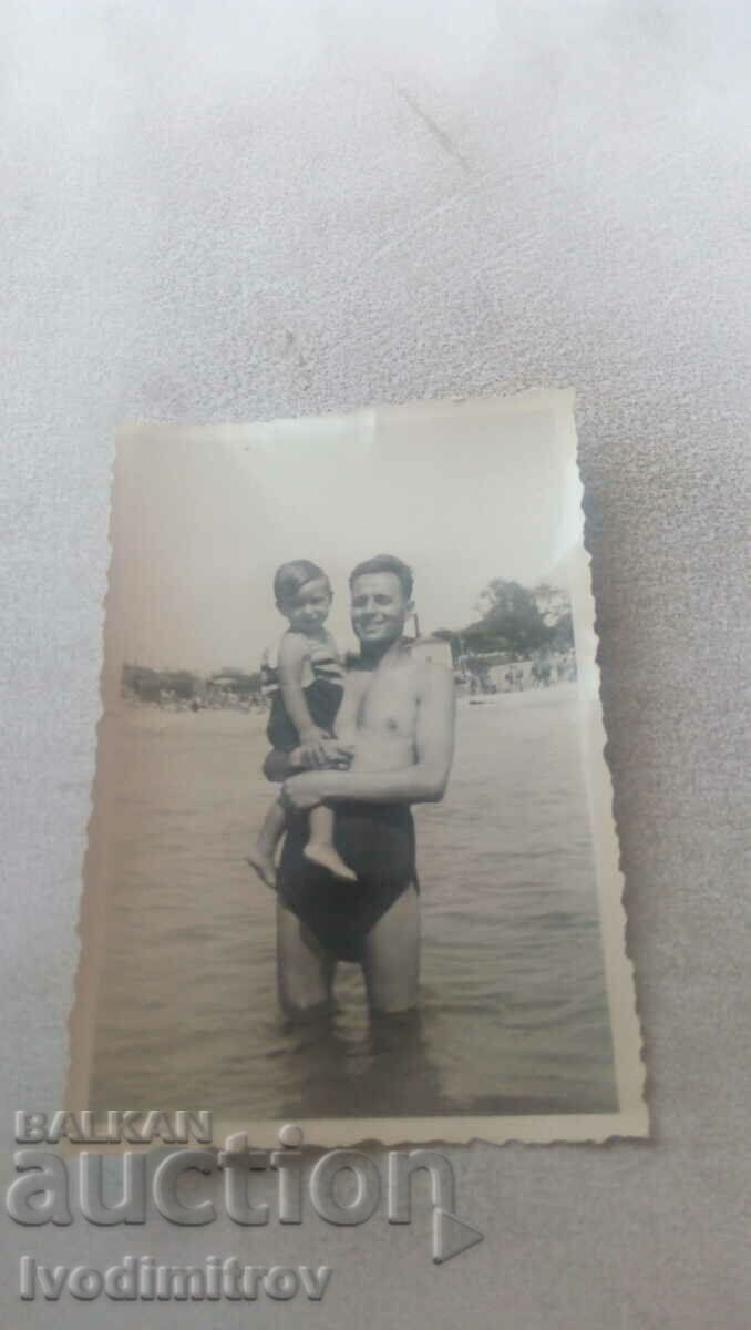 Снимка Мъж и малко момченце на брега на морето