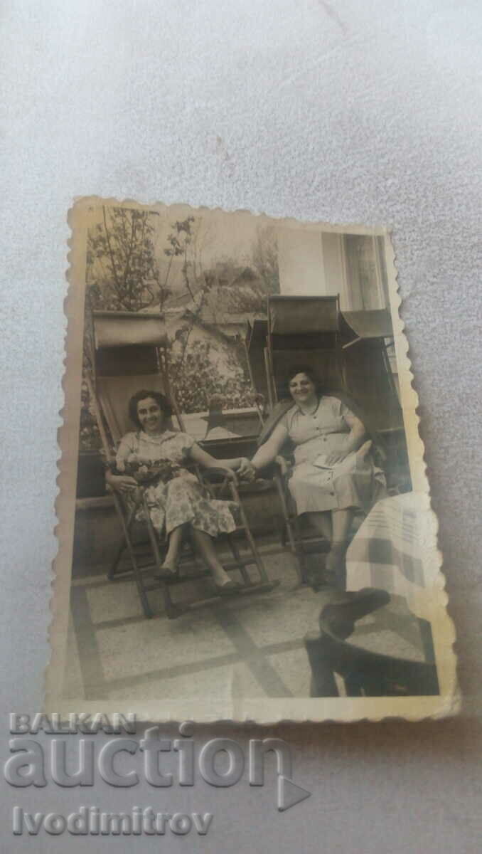 Photo Two women on retro deckchairs in the yard