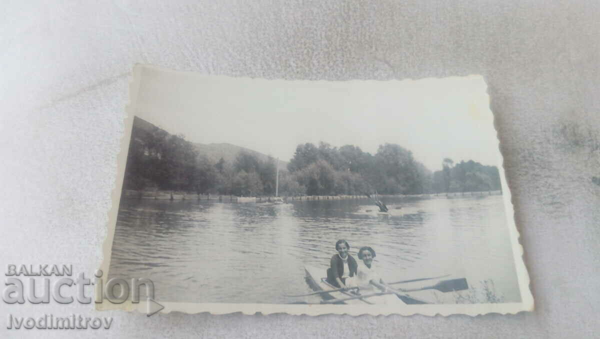 Fotografie Două fete tinere cu o barcă în râu