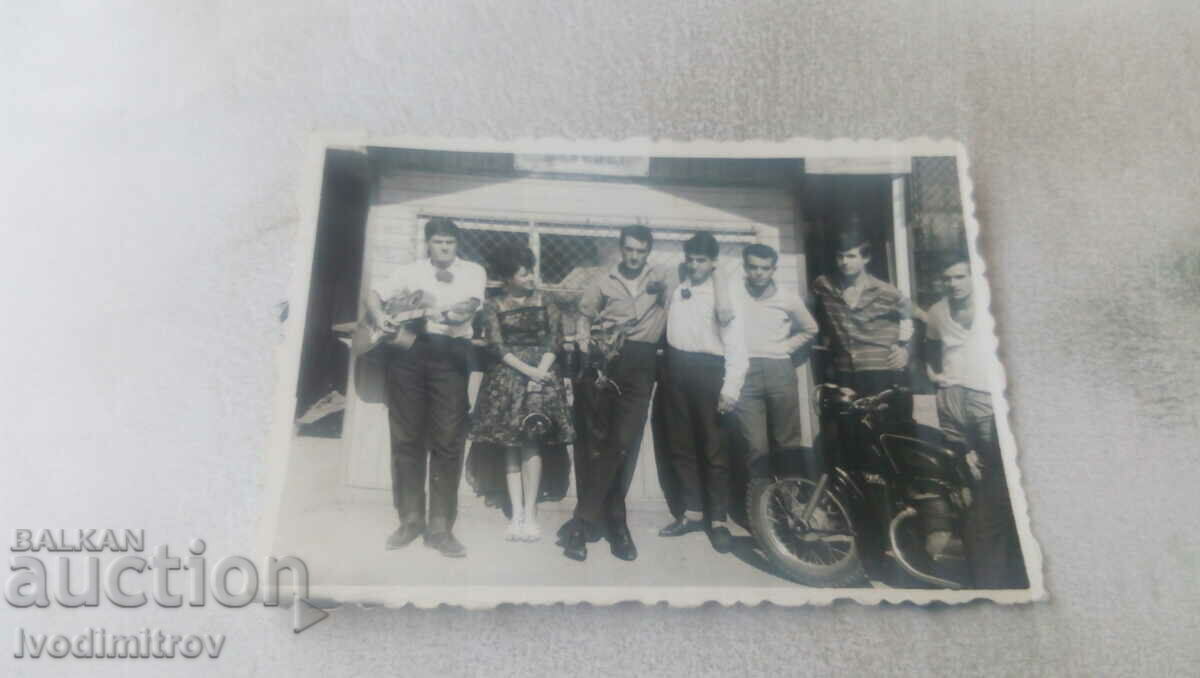 Φωτογραφία Νεαρή γυναίκα και νεαροί άνδρες με μια vintage μοτοσικλέτα
