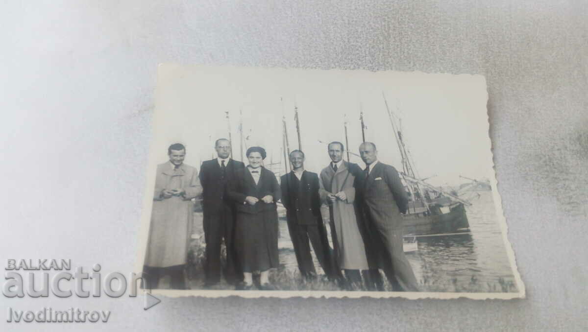 Photo Woman and five men in front of sailboats