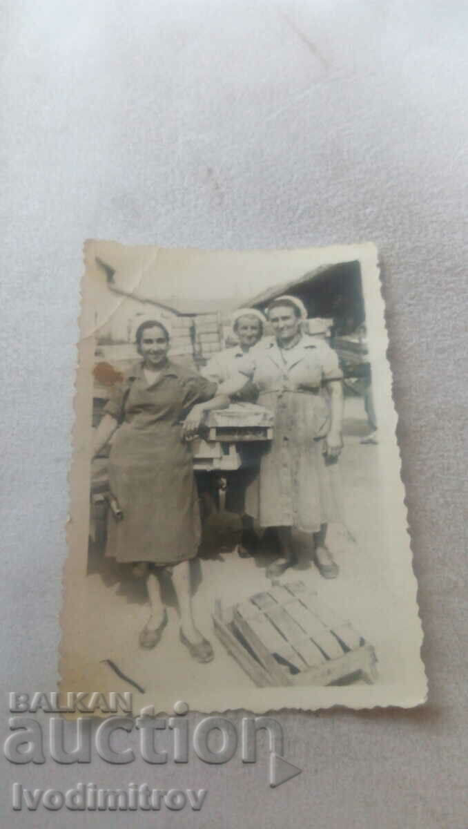 Φωτογραφία Τρεις γυναίκες σε έναν πάγκο αγοράς