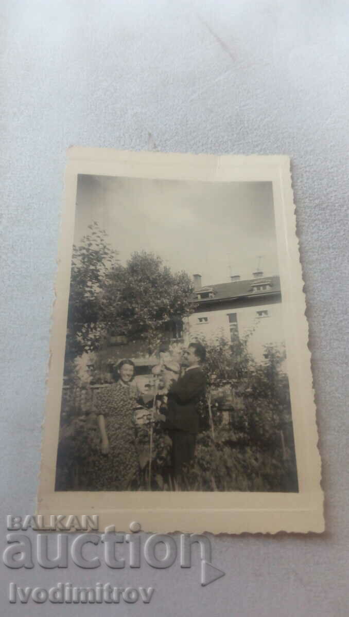 Photo Man, woman and little boy in the yard