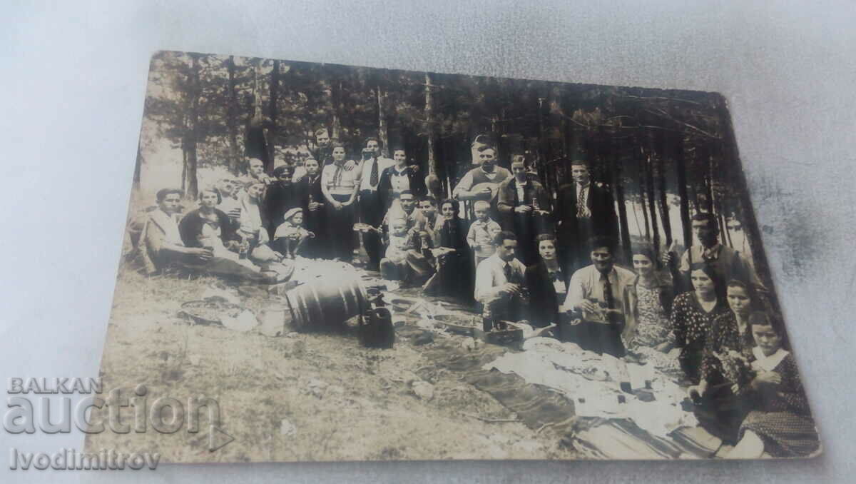 Photo Men women and children on a picnic in the woods