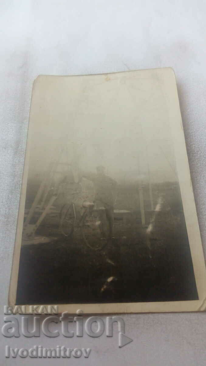 Foto Doi bărbați cu o bicicletă de epocă