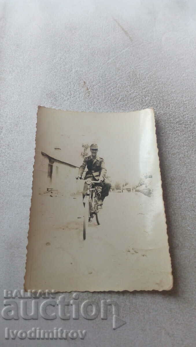 Photo A soldier with a vintage bicycle on the street