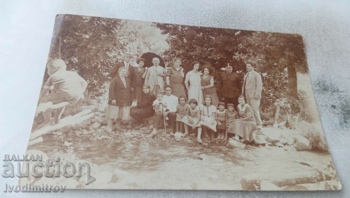 Photo Men, women and children in front of a cave entrance