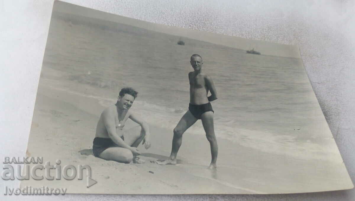 Photo Two men in swimsuits on the beach