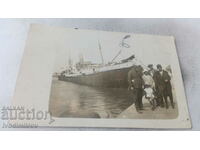Foto Doi bărbați, două femei și o fată în fața unui vapor cu aburi pe stradă