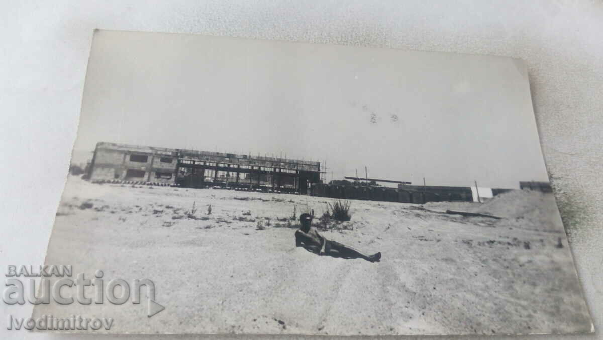 Photo A man in shorts in front of a building under construction