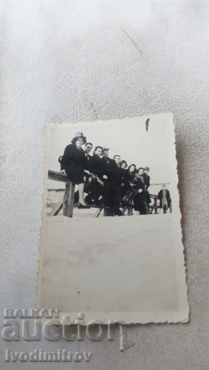 Photo Men and women on a wooden parapet of a bridge