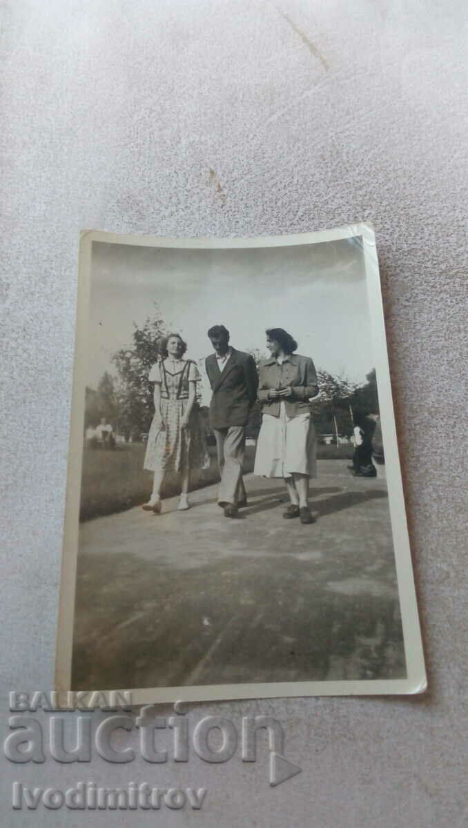 Photo A man and two young women on a walk