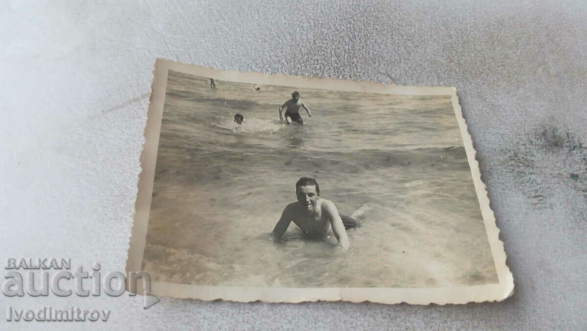 Φωτογραφία Ένας νεαρός άνδρας με vintage μαγιό στην παραλία