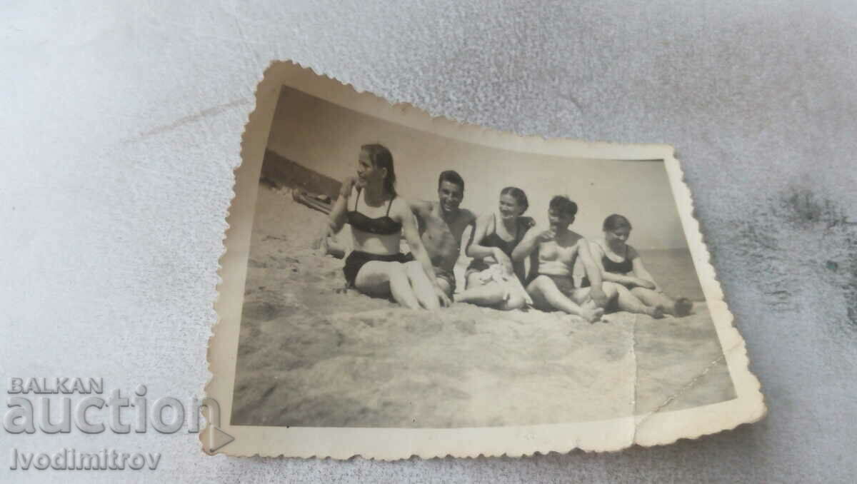 Foto Doi tineri și trei femei pe plajă