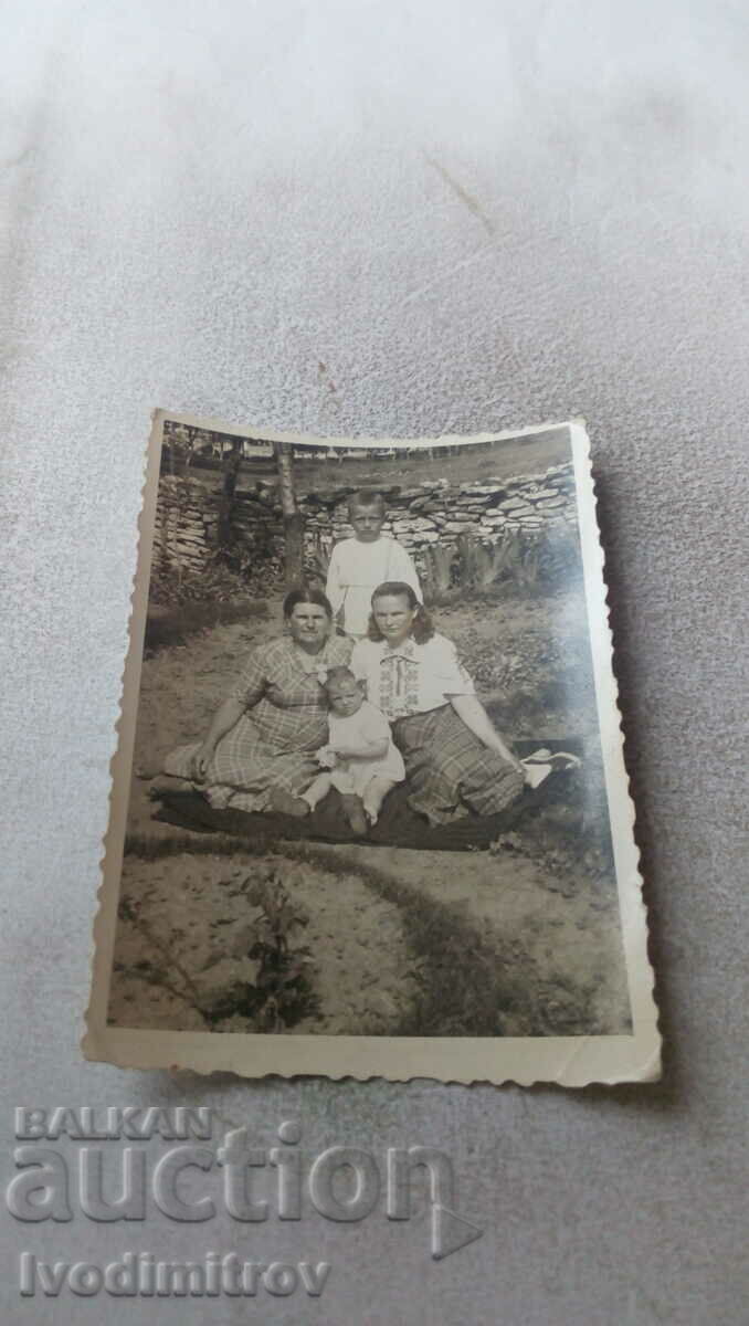 Φωτογραφία Δύο γυναίκες αγόρι και κοριτσάκι στον κήπο