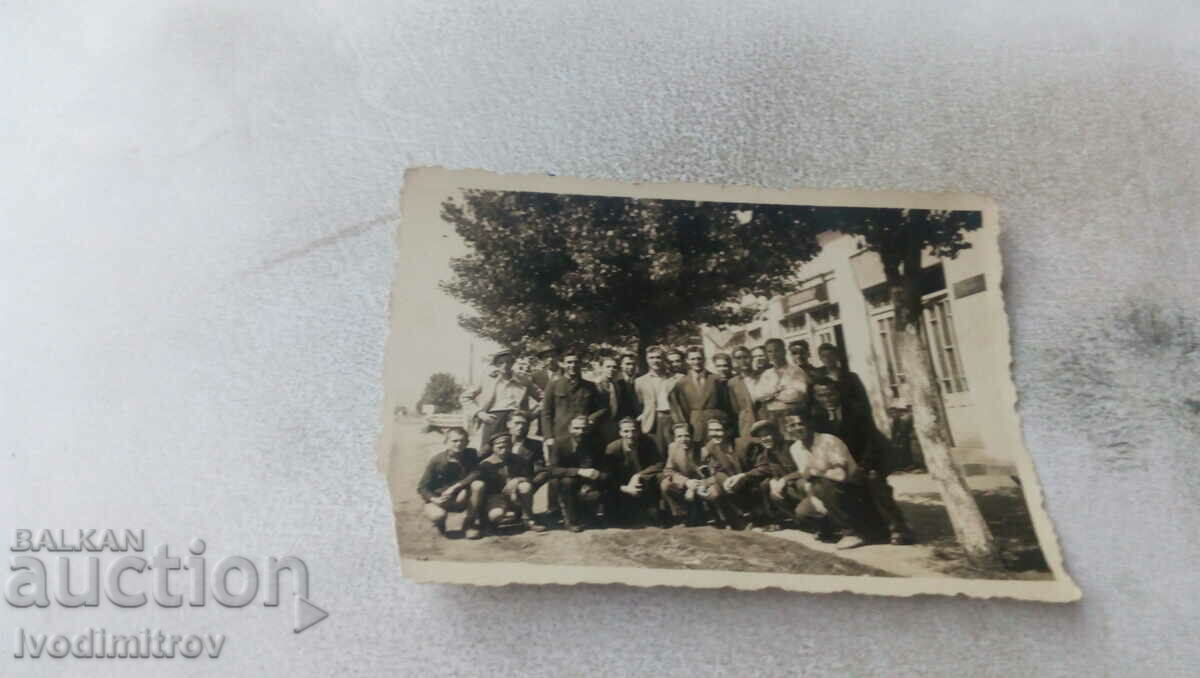 Photo Group of men under a tree in the street