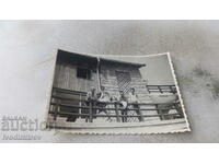 Photo Woman and three men on the railing of a hut in winter