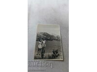 Photo A woman and a man in shorts by a mountain lake