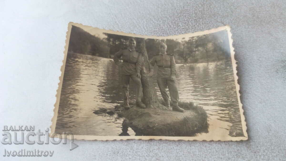 Foto Doi soldați pe o insulă cu un copac în râu