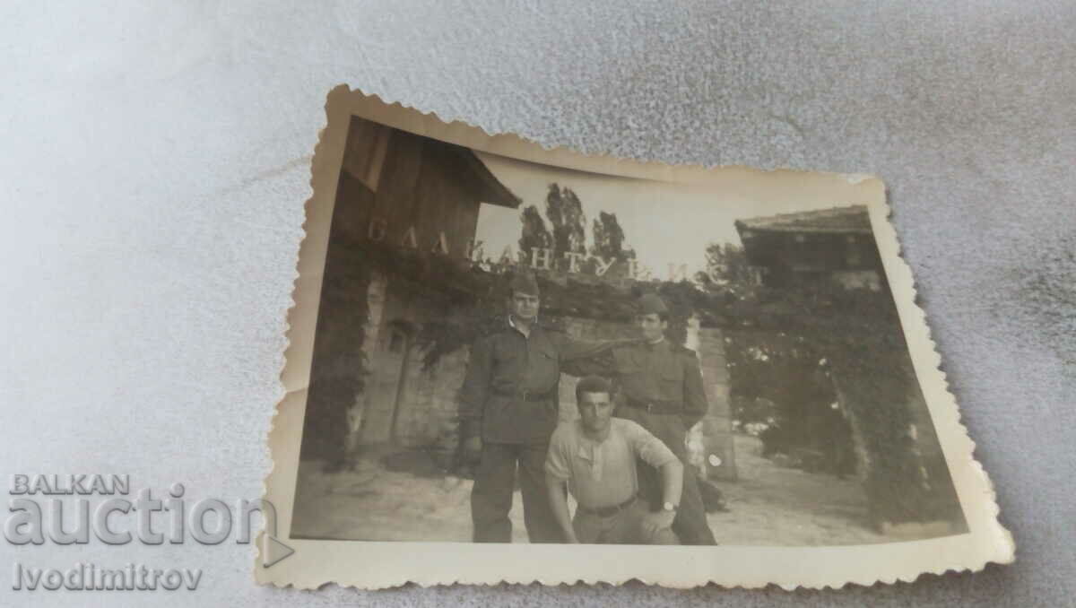 Photo Three soldiers in front of old houses