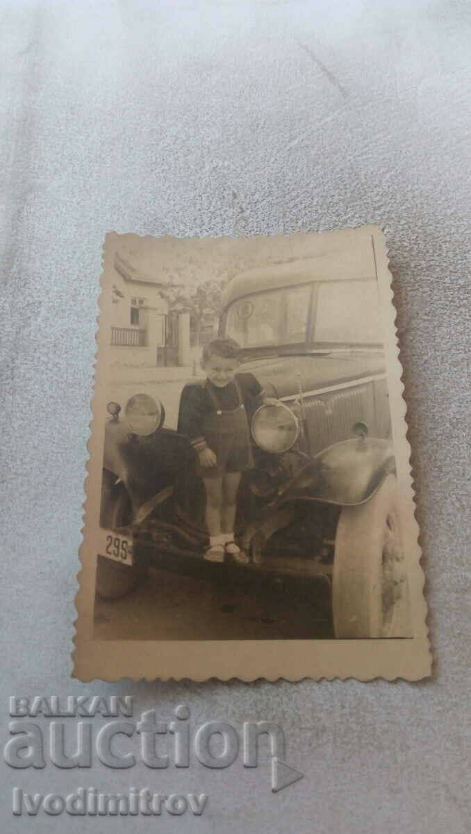Photo Little boy on a vintage car with registration number 299