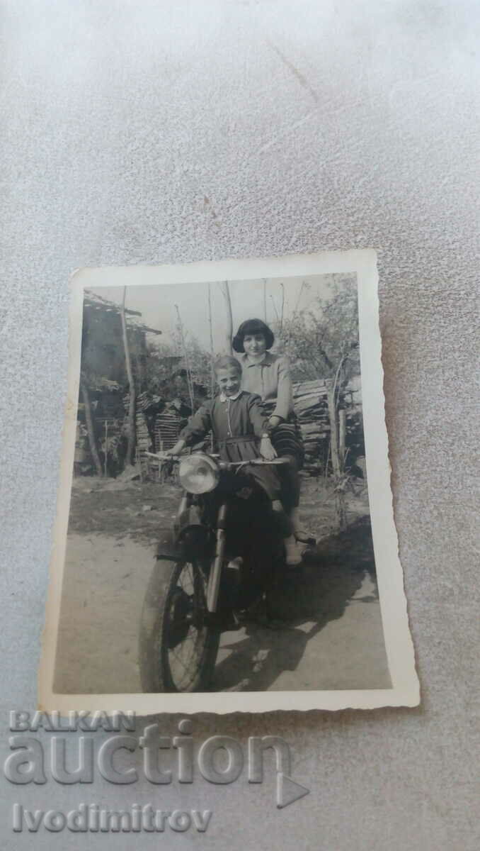 Fotografie Două fete pe o motocicletă de epocă