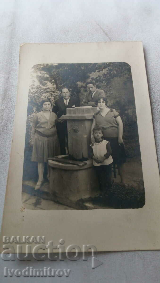 Photo Two men two women and a boy at the fountain