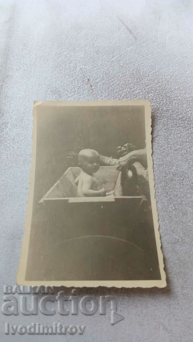 Foto bebeluș într-un jgheab de lemn 1964