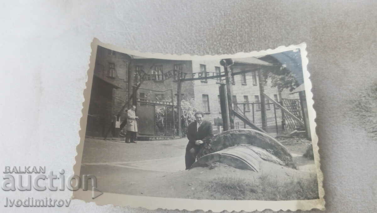 Φωτογραφία Ένας άνδρας μπροστά από την είσοδο του στρατοπέδου συγκέντρωσης του Άουσβιτς