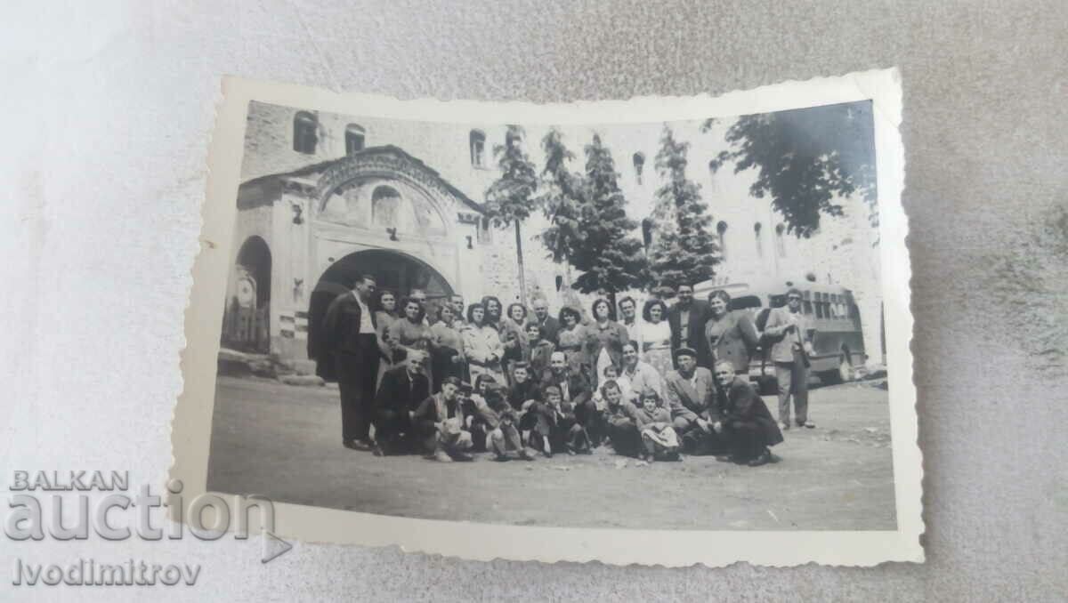 Foto Bărbați, femei și copii în fața unei mănăstiri