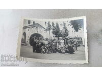 Photo Men, women and children in front of a monastery