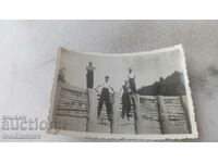 Φωτογραφία Τέσσερις νεαροί άνδρες σε ένα ξύλινο φράγμα