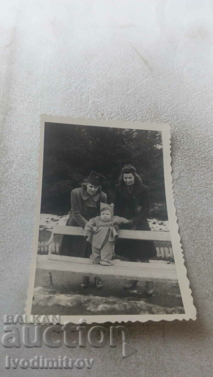 Photo Two women with a baby on a park bench