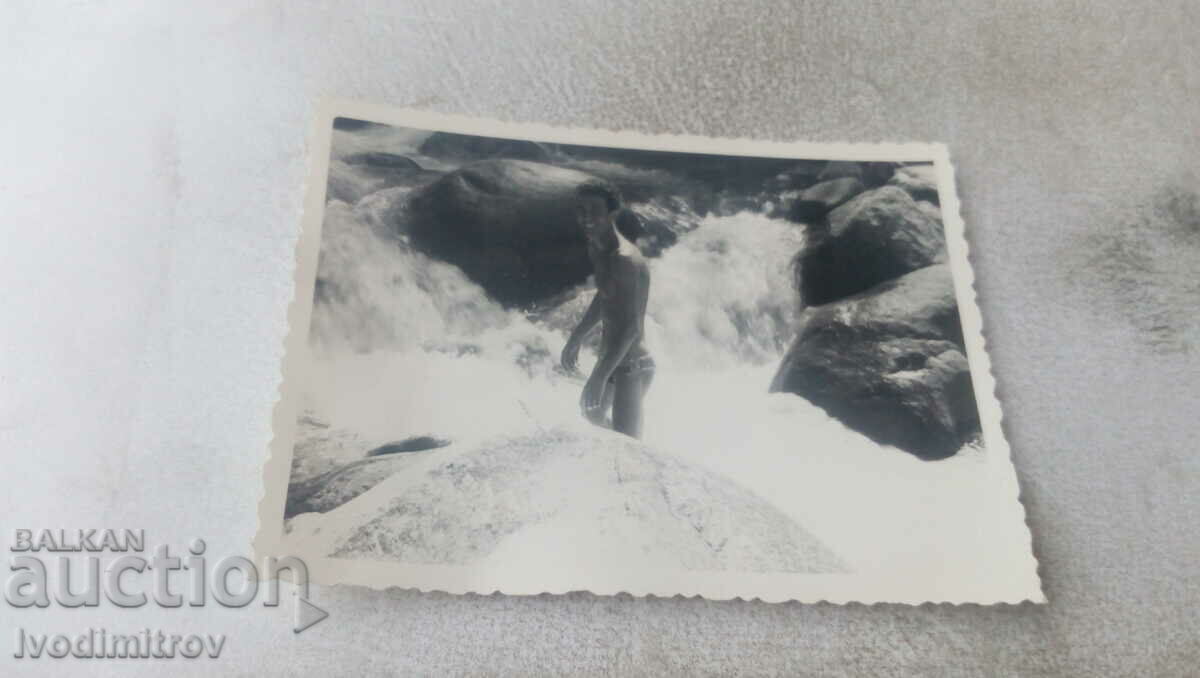 Photo A man in a swimsuit in a raging stream