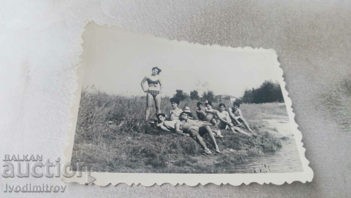 Photo Young men and women on the meadow by the river