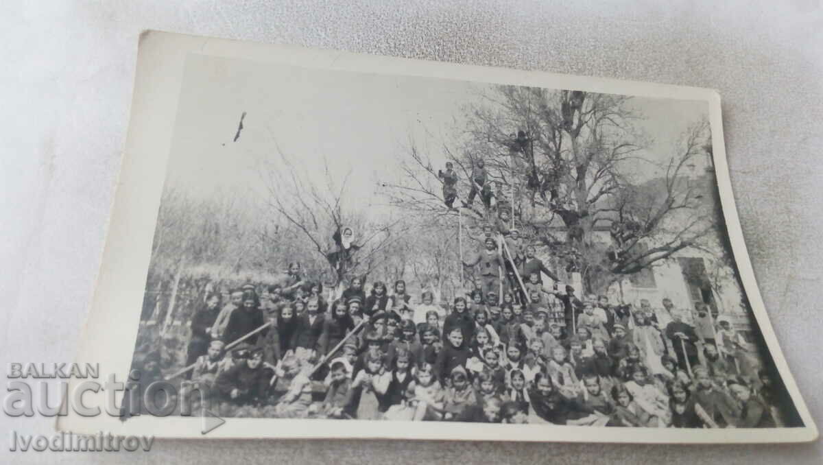 Снимка Мъже жени и деца с мотики в двора на училището