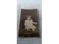 Photo Little girl in a white dress on a chair