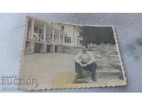 Photo A man sitting on stairs in front of a rest station in the mountains