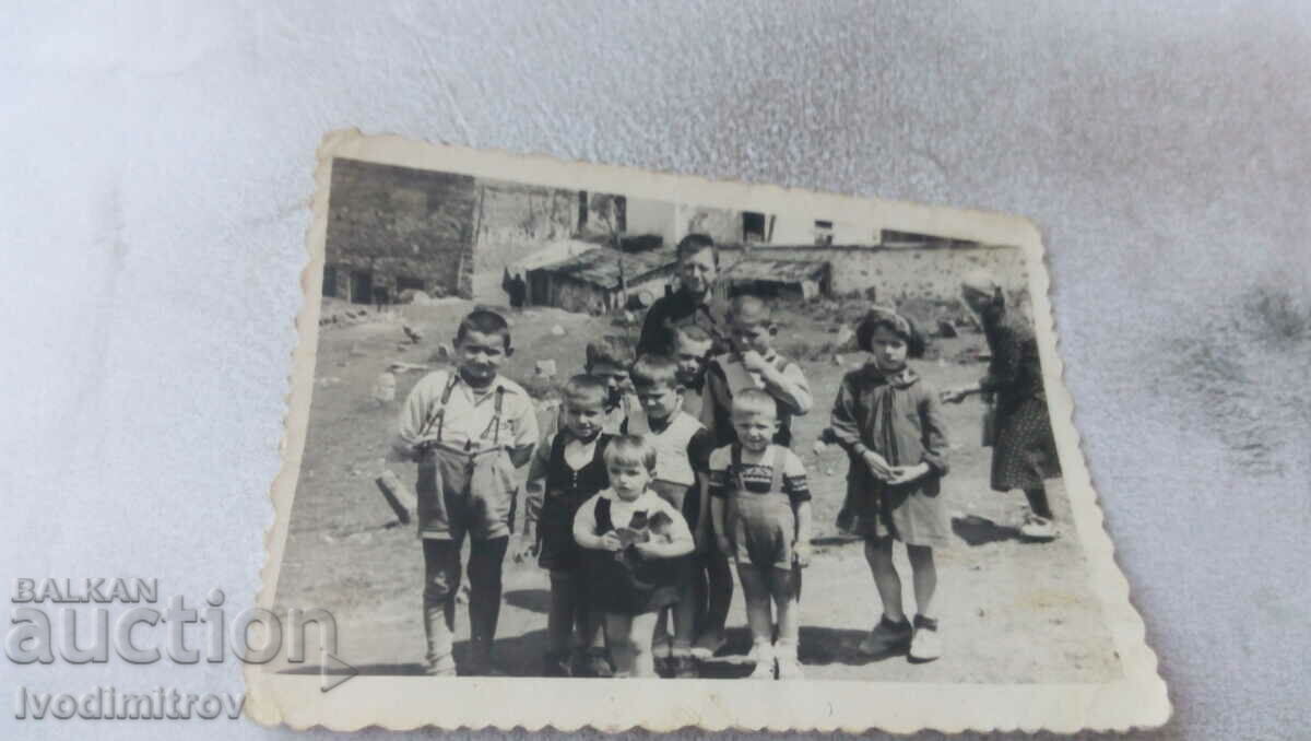Fotografie Un bărbat, o femeie și un grup de copii pe stradă