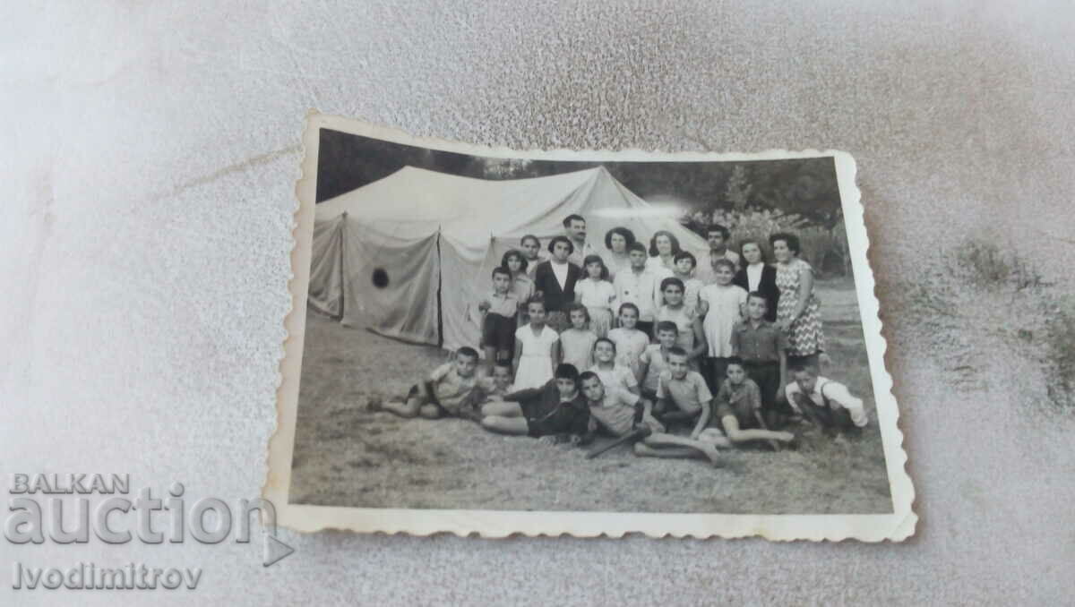 Fotografie Bărbați, femei și copii în fața unui cort mare