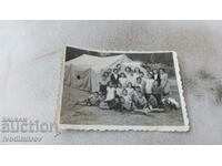 Fotografie Bărbați, femei și copii în fața unui cort mare