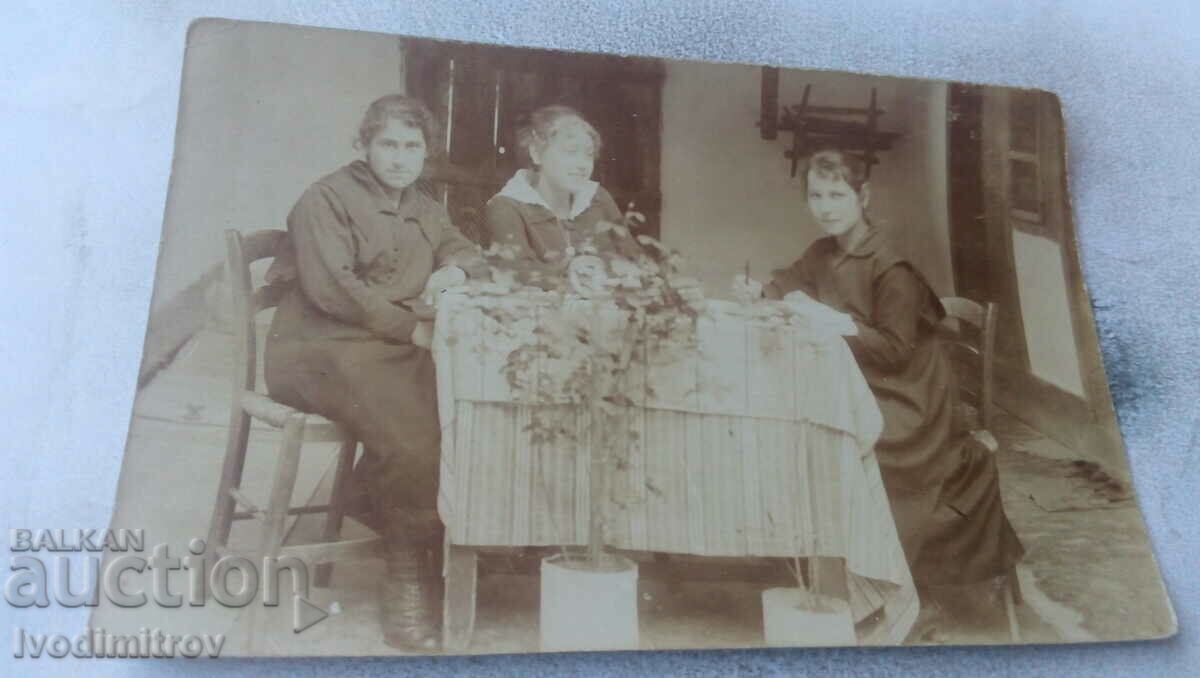 Photo Three young girls at a table in a room