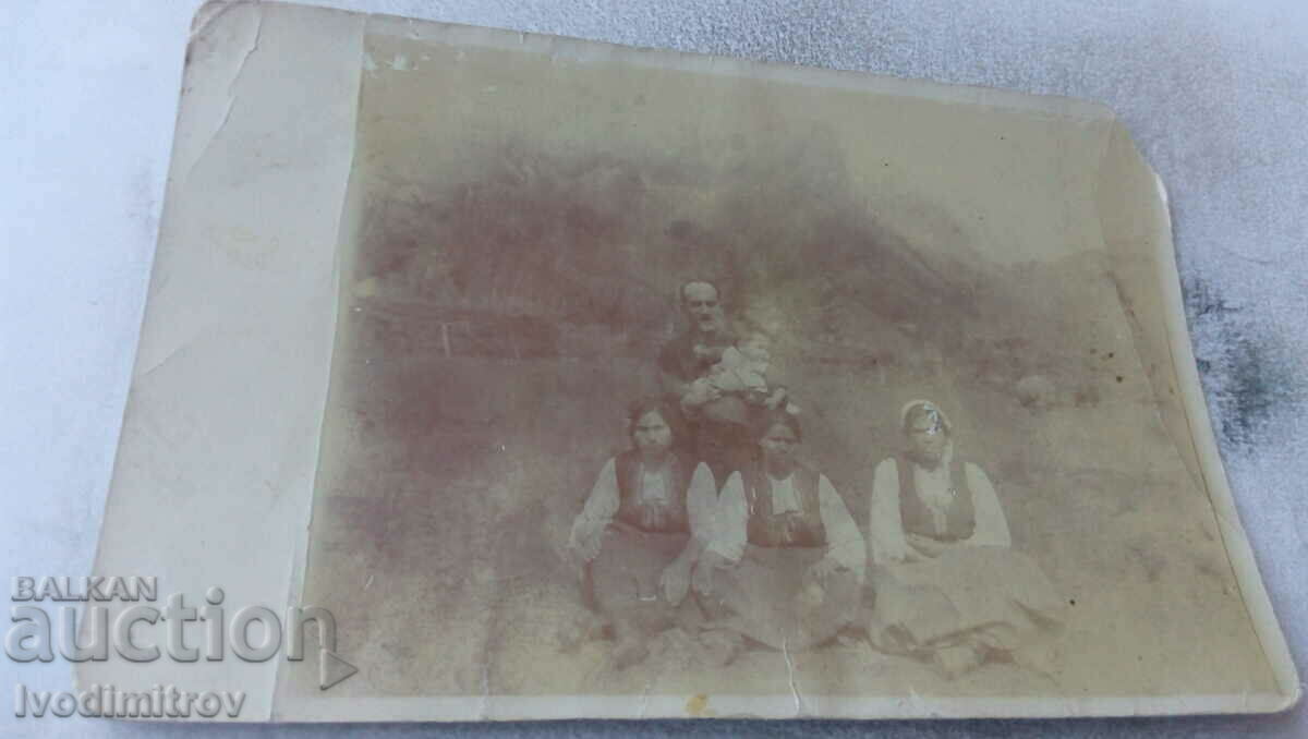 Photo A man with a baby and three women in folk costumes