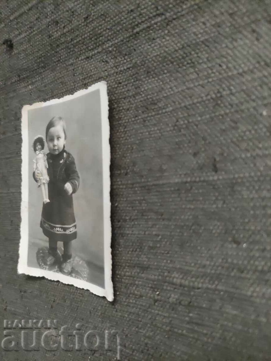 Un copil mic ținând o păpușă 1941