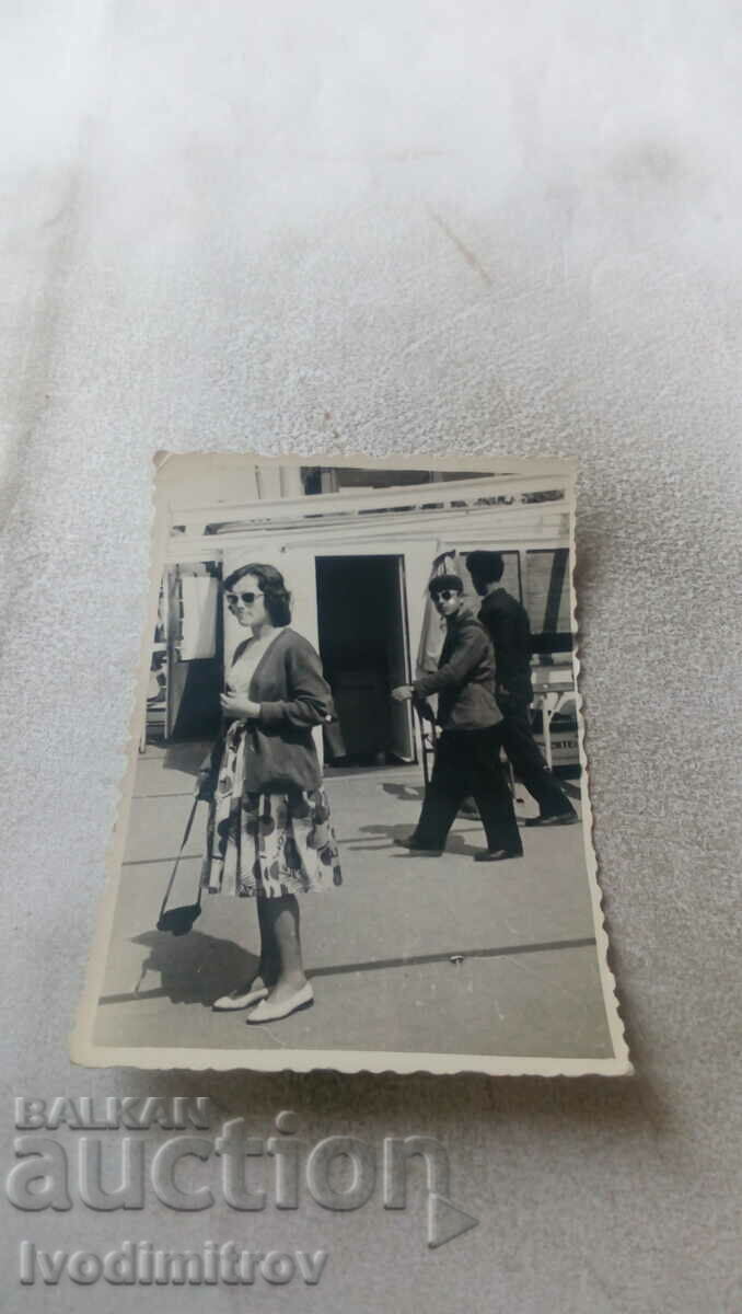 Foto Femeie cu ochelari de soare și un aparat foto la plimbare