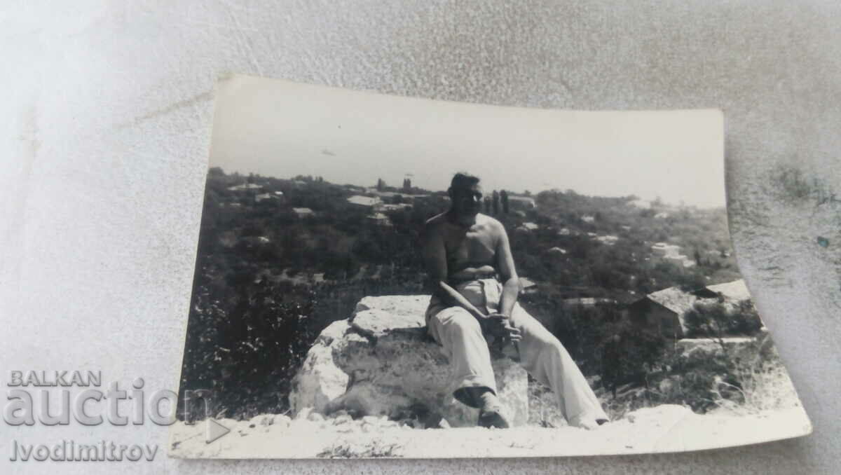 Photo Man naked to the waist sitting on a stone