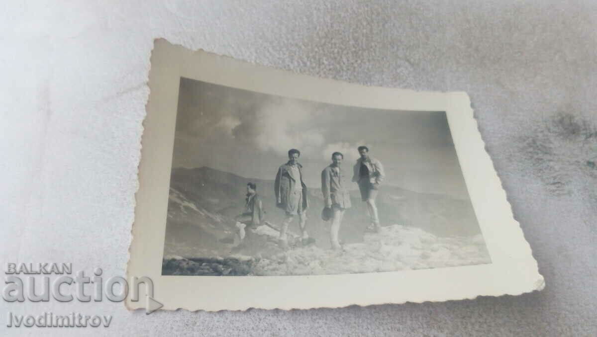 Photo Four young men on top of a mountain