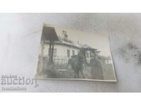 Photo A soldier with a horse in front of a country house