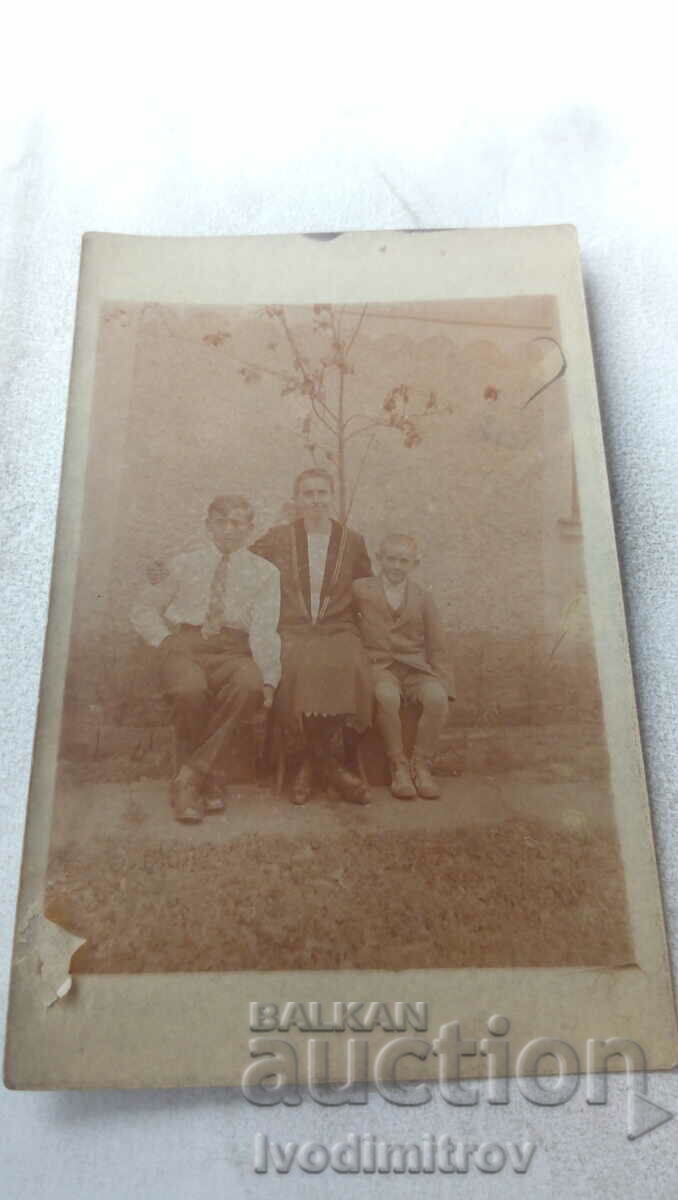 Photo Woman and two boys on a wooden bench