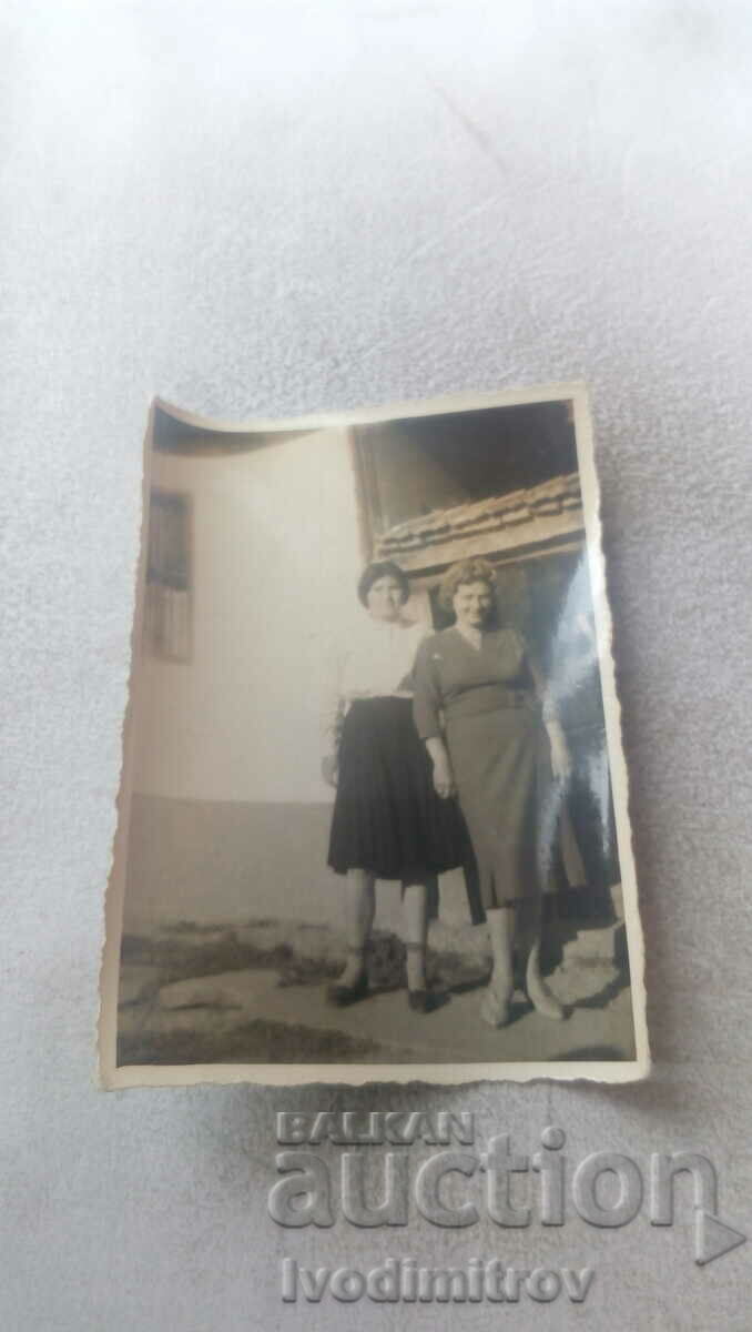 Photo Two women in front of their house